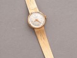 a close up of a gold wrist watch on a gray surface