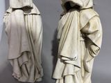 two statues of a man and a woman dressed in hooded clothing