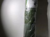 a roll of green grass wrapped in plastic on a table