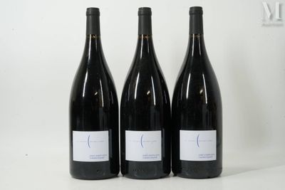 trois bouteilles de vin rouge sont posées sur une surface blanche