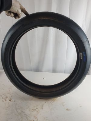 someone is holding a tire that has been placed on a table