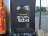 une poubelle située à côté d'une boîte aux lettres