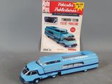 a toy bus that is sitting next to a magazine