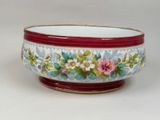 un bol rouge et blanc orné de fleurs peintes