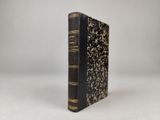un livre noir et or posé sur une table blanche