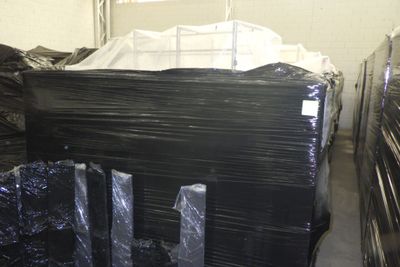une grande pile de sacs en plastique noirs dans un entrepôt