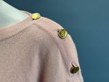 the back of a pink sweater with gold buttons on a mannequin mannequin mannequin mannequin mannequin mannequin mannequin