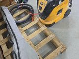a yellow and black vacuum sitting on a pallet in a garage