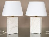 une paire de lampes en marbre blanc avec des abat-jours, posées sur une table