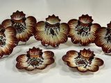 six fleurs marron et blanches sont posées sur une surface blanche