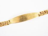 gros plan d'un bracelet en or sur une surface blanche