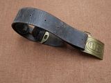 une vieille ceinture avec une boucle en laiton sur fond marron