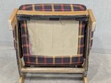 a wooden chair with a plaid cover on it