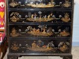 une commode noire sur laquelle est posé un tableau