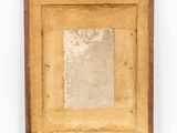 an old picture frame is hanging on a white wall