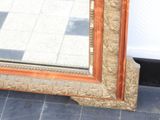 a large mirror sitting on the floor in front of a wall