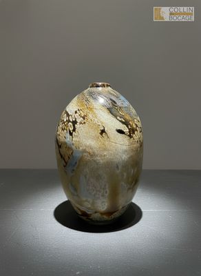 un vase posé sur une table sur laquelle est allumée une lampe