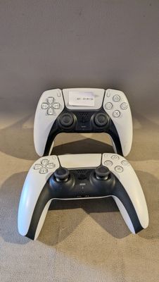 deux manettes de jeux vidéo posées l'une à côté de l'autre sur le sol