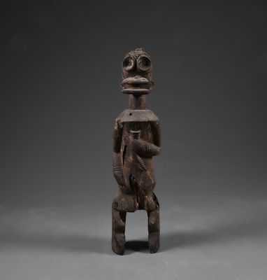 une figurine en bois représentant un homme à la tête et aux bras volumineux