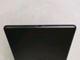 the back of a black laptop computer sitting on top of a table