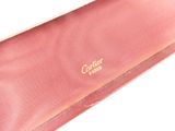 pink tie with gold lettering on it sitting on a white surface