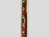 a close up of a gold and red clock on a stand