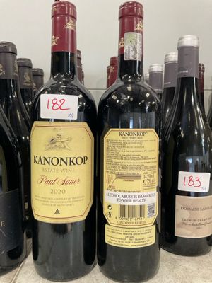 plusieurs bouteilles de vin sont alignées sur une étagère