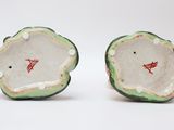 pair of small green and white vases with red designs on them