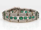 a close up of a bracelet with emeralds and diamonds