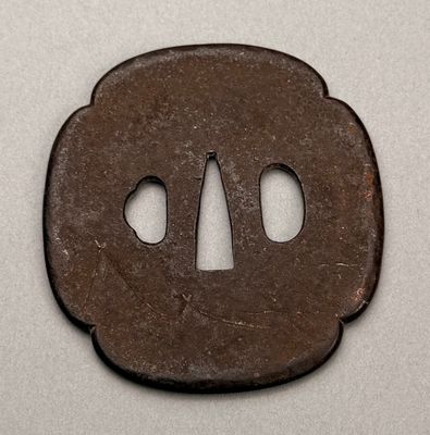 an old iron tsubai with two holes in the middle of it