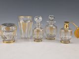 Plusieurs bouteilles et vases en verre sont alignés sur une table