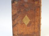 an old book that is sitting on a white surface