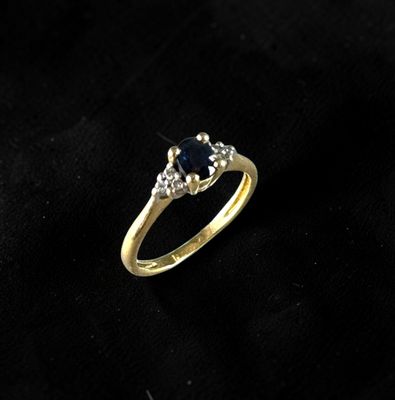 a gold ring with a sapphire stone and diamonds