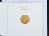 a close up of a piece of paper with a gold coin on it