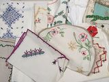 de nombreux types de nappes brodées disposées sur une table