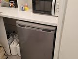 a small kitchen with a microwave and a dishwasher in it