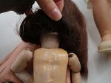 a person holding a doll that is sitting on a table