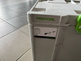 a white trash can with a green tag on it