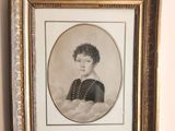 an old picture of a woman in a black dress is hanging on a wall