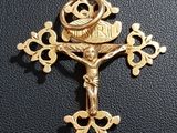 gold plated crucift with a cross on a black leather surface