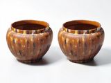 deux vases bruns posés l'un à côté de l'autre sur une surface blanche