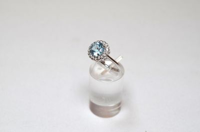 an image of a ring with a blue topaz stone on a white surface