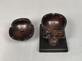 two small wooden bowls and a small bowl on a stand