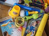 une boîte remplie de jouets et un livre posés sur une table