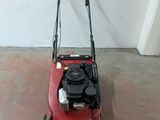 a red lawn mower that is sitting on the ground