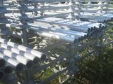 de nombreux tuyaux qui traînent dans l'herbe près de la clôture
