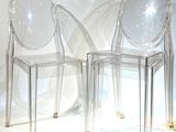 deux chaises transparentes placées l'une à côté de l'autre sur une surface blanche