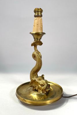 une lampe de table ancienne en laiton sur laquelle est posé un oiseau