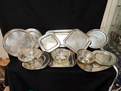 de nombreux plats et plateaux en argent posés sur une table