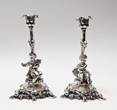 une paire de bougeoirs en argent ornés de figures